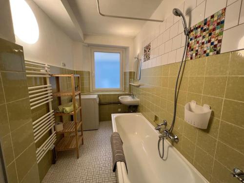 a green bathroom with a tub and a sink at Gemütliches Haus mit 2 Zimmern in Vallendar