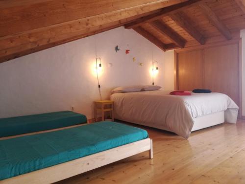sypialnia z 2 łóżkami w pokoju z drewnianym sufitem w obiekcie Casa14 w mieście Odeceixe