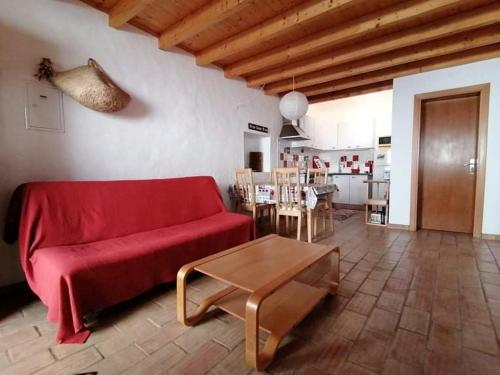 a living room with a red couch and a table at Casa14 in Odeceixe