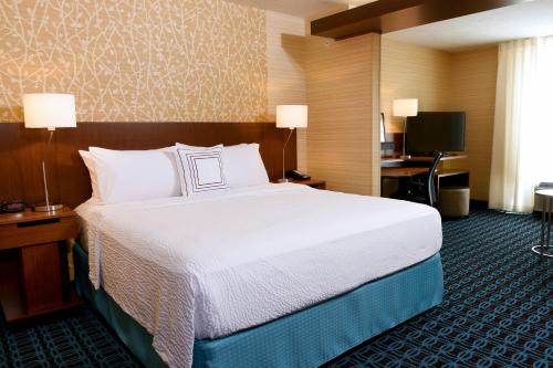 a hotel room with a large bed and a desk at Fairfield Inn & Suites by Marriott Omaha West in Omaha