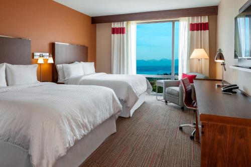 シータックにあるフォー ポインツ バイ シェラトン シアトル エアポート サウスのベッド2台と大きな窓が備わるホテルルームです。