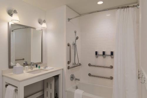 a white bathroom with a sink and a shower at Four Points by Sheraton Seattle Airport South in SeaTac