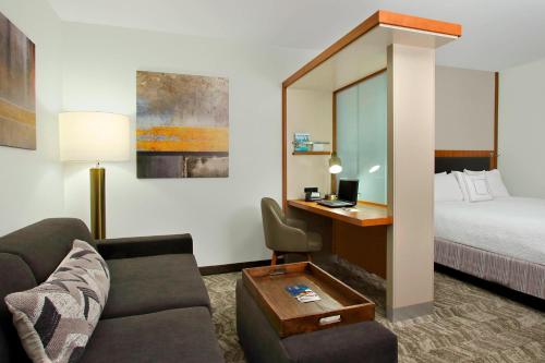 um quarto de hotel com uma cama, um sofá e uma secretária em SpringHill Suites by Marriott Madera em Madera