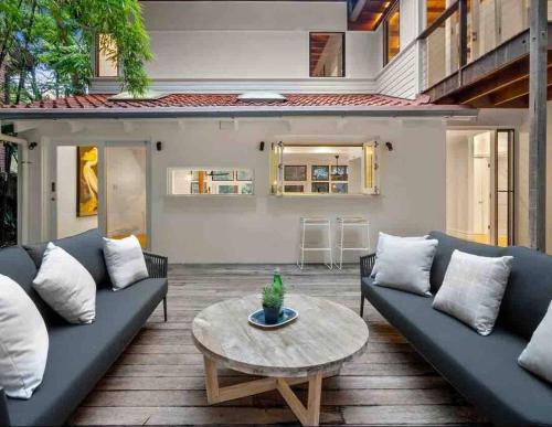 a living room with a couch and a table at Sydney Northern Beaches Waterfront Pittwater Avalon Beach - Clareville in Clareville