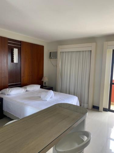 una habitación de hotel con una cama grande y una mesa en Flat Lake Side Linda Vista Lago c/banheira, en Brasilia