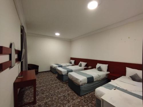 pokój hotelowy z 2 łóżkami i kanapą w obiekcie Athman Hotel w Mekce