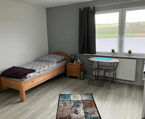 - une chambre avec un lit, une table et une fenêtre dans l'établissement Mellys Café & Store, à Einbeck