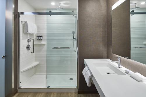 a bathroom with a glass shower and a sink at AC Hotel by Marriott Atlanta Airport Gateway in Atlanta