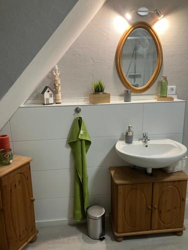 La salle de bains est pourvue d'un lavabo et d'un miroir. dans l'établissement Mellys Café & Store, à Einbeck