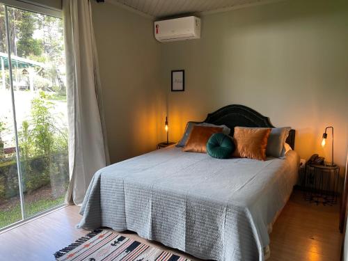 1 dormitorio con cama y ventana grande en Pousada Villa Cantaloa, en Gramado