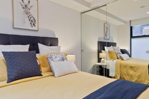 Un dormitorio con dos camas y un espejo. en PORT MELBOURNE - A stay at the Bay, en Melbourne