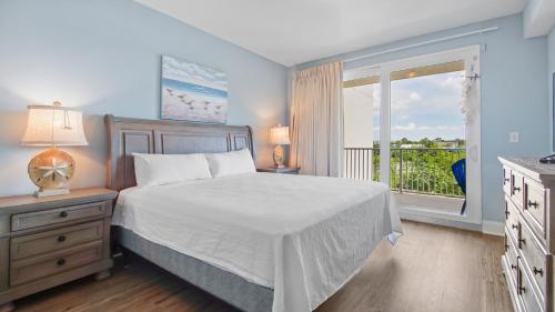 a bedroom with a bed and a window with a balcony at Laketown Wharf #101 by Nautical Properties Vacation Rentals in Panama City Beach