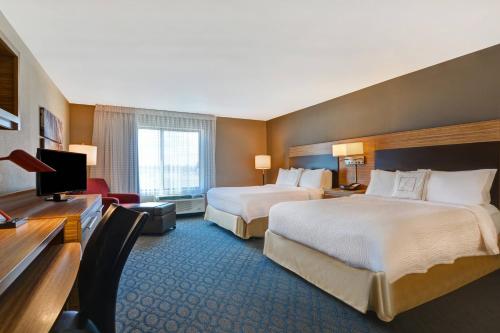 a hotel room with two beds and a desk at TownePlace Suites by Marriott Alexandria in Alexandria