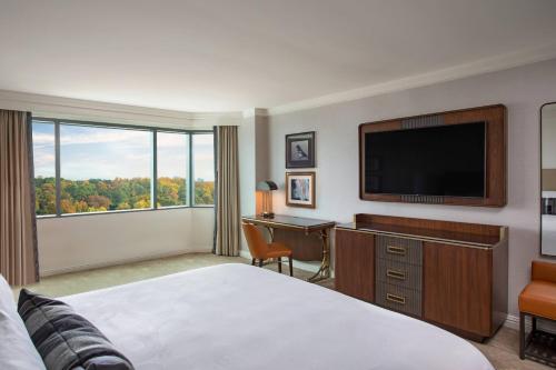 a hotel room with a bed and a flat screen tv at JW Marriott Atlanta Buckhead in Atlanta