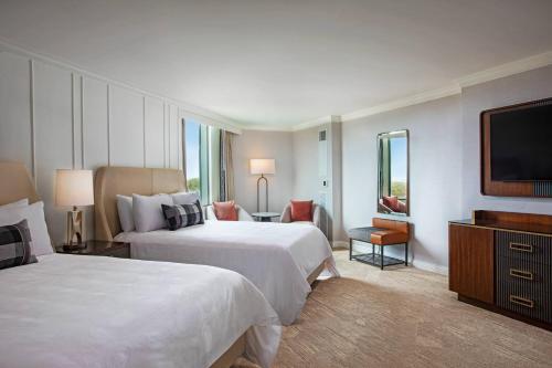 a hotel room with two beds and a flat screen tv at JW Marriott Atlanta Buckhead in Atlanta
