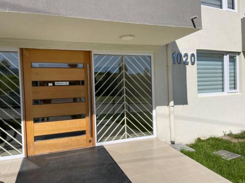 una puerta de madera a una casa con ventana en Departamento nuevo en exclusivo sector de Puerto Montt, en Puerto Montt