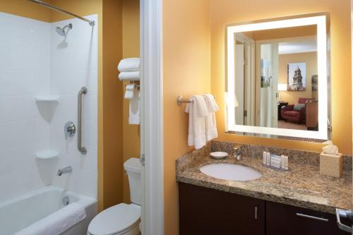 a bathroom with a sink and a toilet and a mirror at TownePlace Suites by Marriott Detroit Troy in Troy