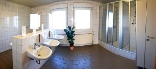 a bathroom with two sinks and two mirrors at Pension ZUM LINDENWALD Colbitz in Kolbitz