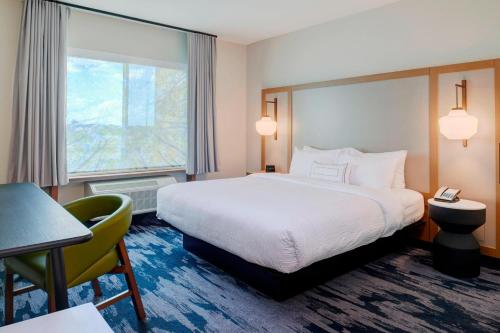 a hotel room with a bed and a desk and a window at Fairfield Inn & Suites by Marriott Columbus, IN in Columbus