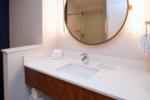 Fairfield Inn & Suites by Marriott Columbus, IN في كولومبوس: حمام مع حوض أبيض ومرآة