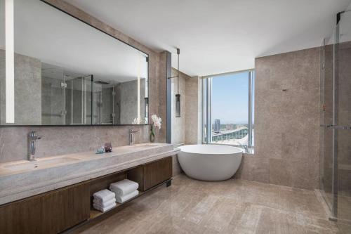 La salle de bains est pourvue d'une grande baignoire et d'une grande fenêtre. dans l'établissement Courtyard by Marriott Chengdu South, à Chengdu