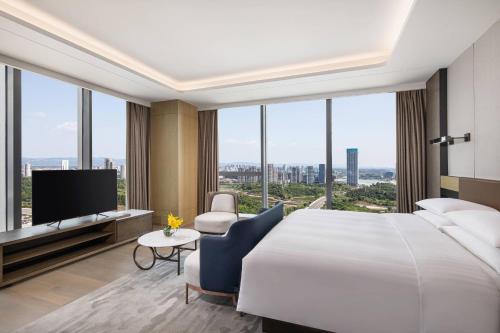 a hotel room with a large bed and a television at Courtyard by Marriott Chengdu South in Chengdu