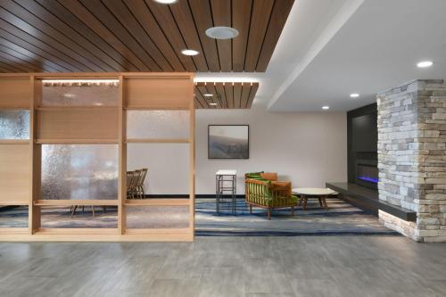 a living room with a fireplace and a stone wall at Fairfield Inn & Suites by Marriott Pottstown Limerick in Pottstown