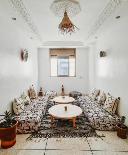 a living room with couches and a table at cactus surf house in Tamraght Ouzdar