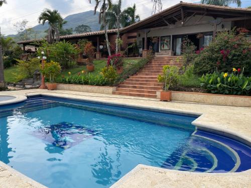 a swimming pool in front of a house at Finca hotel Villa Camila in Copacabana