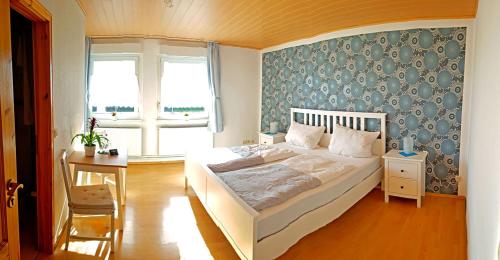 a bedroom with a white bed with a blue wall at Pension ZUM LINDENWALD Colbitz in Kolbitz