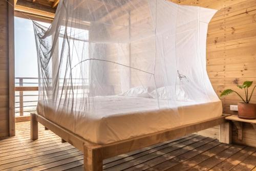a bed in a room with a mosquito net at Mendihuaca Surf Camp in Guachaca