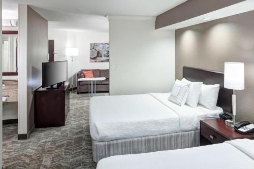 a hotel room with two beds and a flat screen tv at SpringHill Suites Columbus in Columbus