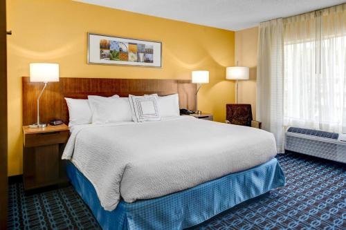 a hotel room with a large bed and a window at Fairfield Inn and Suites by Marriott Atlanta Suwanee in Suwanee
