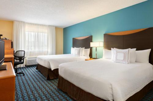 a hotel room with two beds and a flat screen tv at Fairfield Inn & Suites by Marriott Toledo Maumee in Maumee