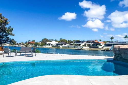a large swimming pool with two chairs next to it at Pay for 3 nights, get 4th night for free in March in Maroochydore