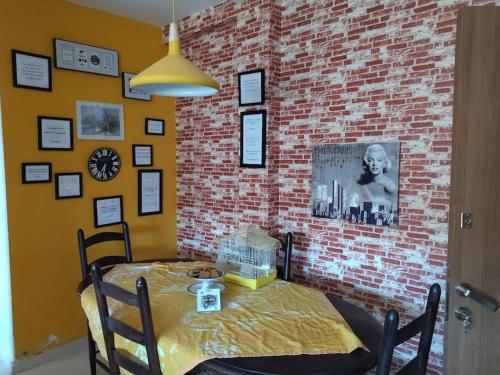 a dining room with a table and a brick wall at Apparemment in Oujda