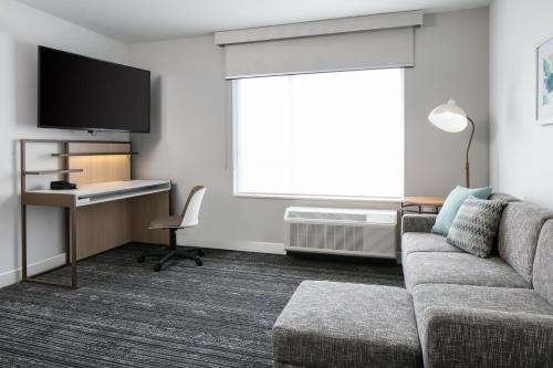 a living room with a couch and a tv at TownePlace Suites by Marriott Oconomowoc in Oconomowoc