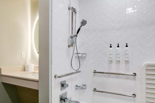 a white bathroom with a shower and a sink at TownePlace Suites by Marriott Oconomowoc in Oconomowoc