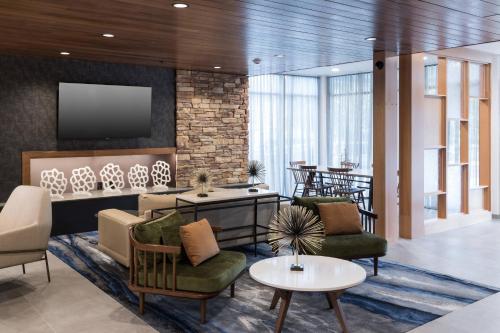 vestíbulo con sillas, TV y mesa en Fairfield Inn & Suites by Marriott Savannah I-95 North en Port Wentworth