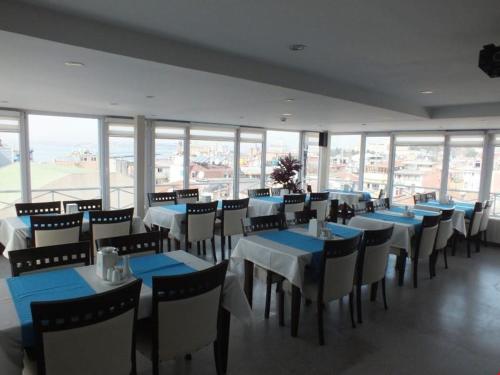 a restaurant with blue tables and chairs and windows at Şirin Hotel in Istanbul