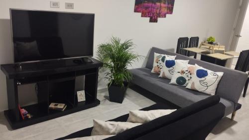 een woonkamer met een bank en een flatscreen-tv bij Hermoso Apartamento en Circasia, Quindío. in Circasia