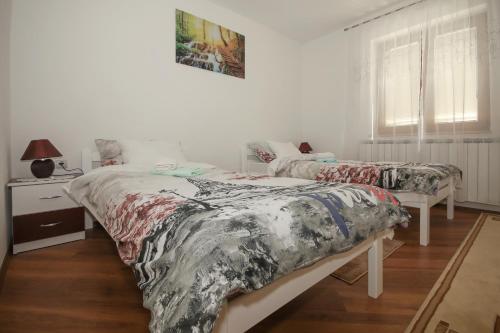 een slaapkamer met 2 bedden, een tafel en een raam bij Apartments with a parking space Licko Lesce, Velebit - 20985 in Otočac