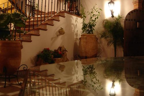 a room with a staircase with potted plants and a glass table at Hotel Rural Andalucia in Sierra de Yeguas