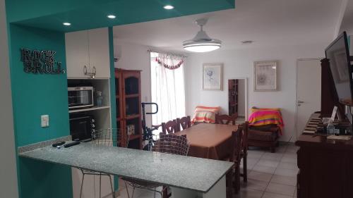 kuchnia i salon ze stołem i krzesłami w obiekcie Departamento el estadio w mieście Santiago del Estero