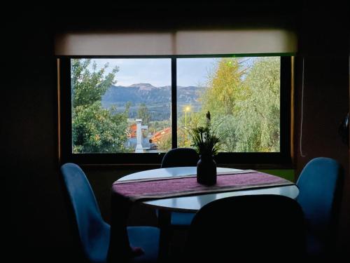een tafel met een vaas voor een raam bij Apartamento Coyhaique in Coihaique