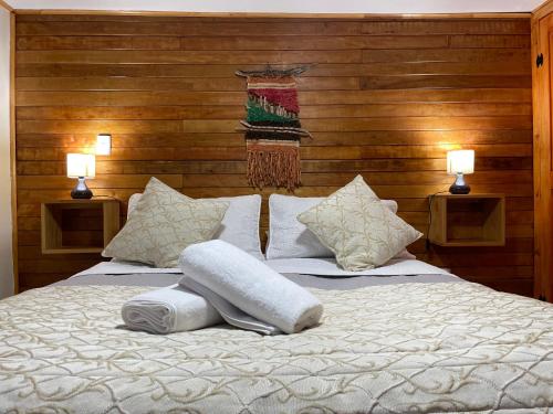 een slaapkamer met een groot wit bed met 2 lampen bij Apartamento Coyhaique in Coihaique