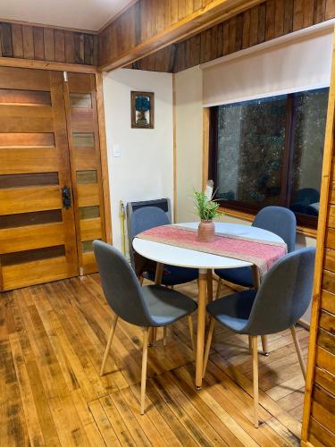 a dining room with a table and chairs and a window at Apartamento Coyhaique in Coihaique