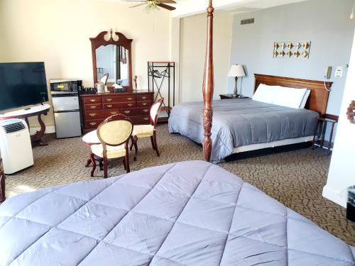 Monte Vista的住宿－Monte Villa Hotel，一间卧室配有一张床、一张书桌和一台电视
