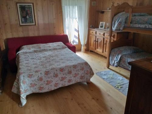 een slaapkamer met 2 bedden in een houten kamer bij Casa Mimosa 1 in Gressan