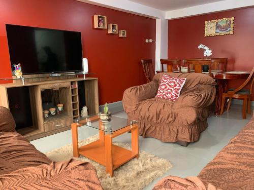 a living room with two chairs and a flat screen tv at El Viejo Roble in Cusco